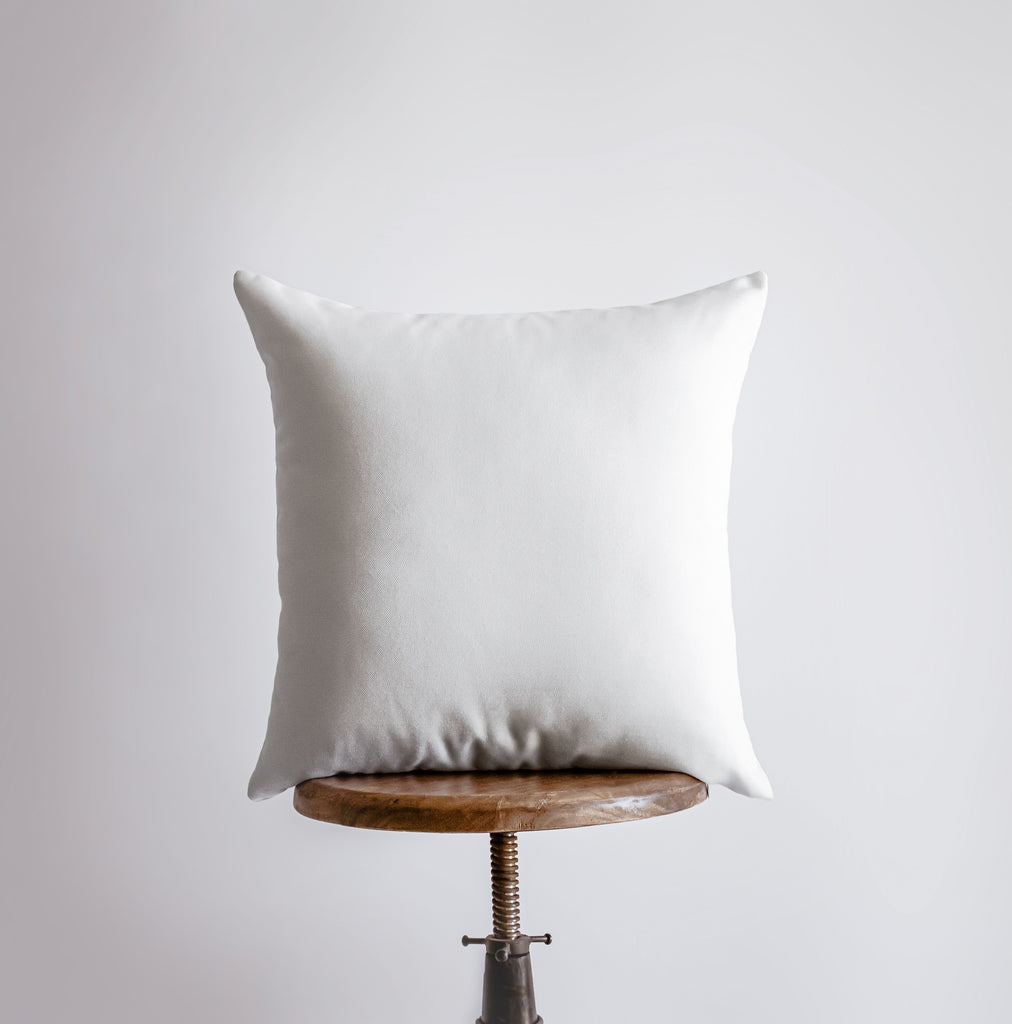 a white pillow sitting on top of a wooden table