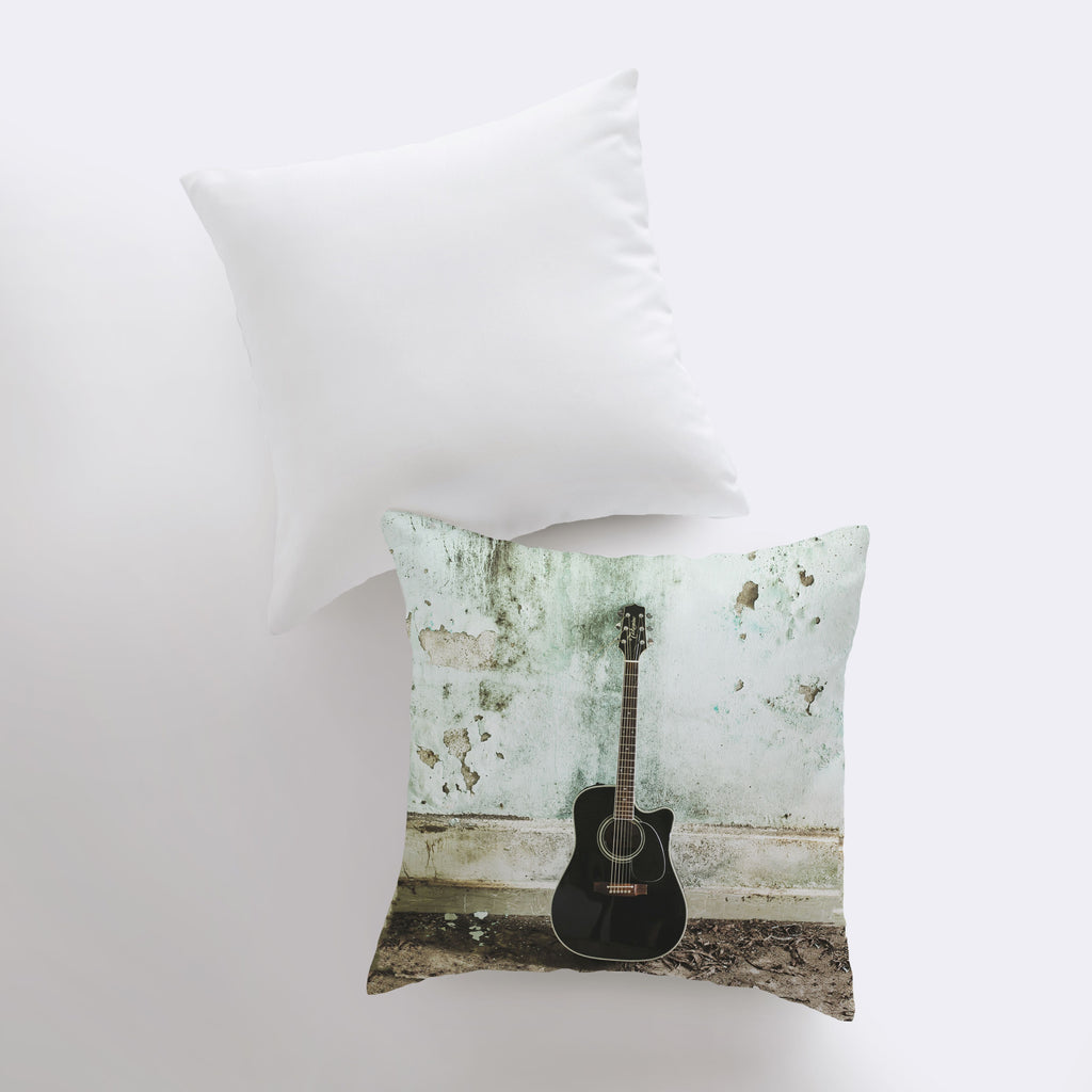 a guitar pillow sitting on top of a white pillow