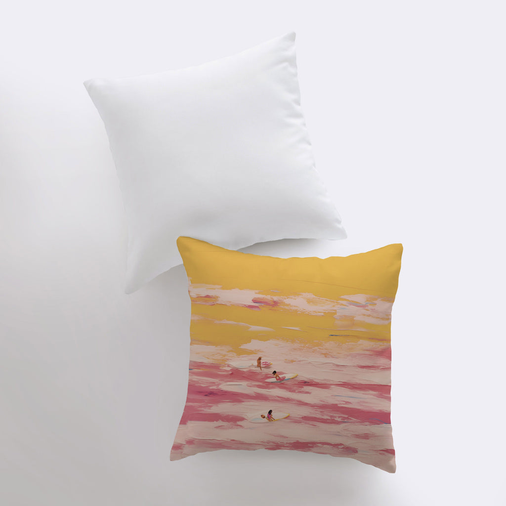 a yellow and pink pillow sitting on top of a white bed