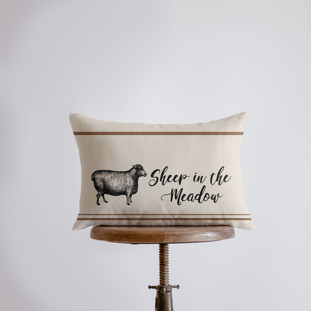 a pillow with a sheep in the meadow on it