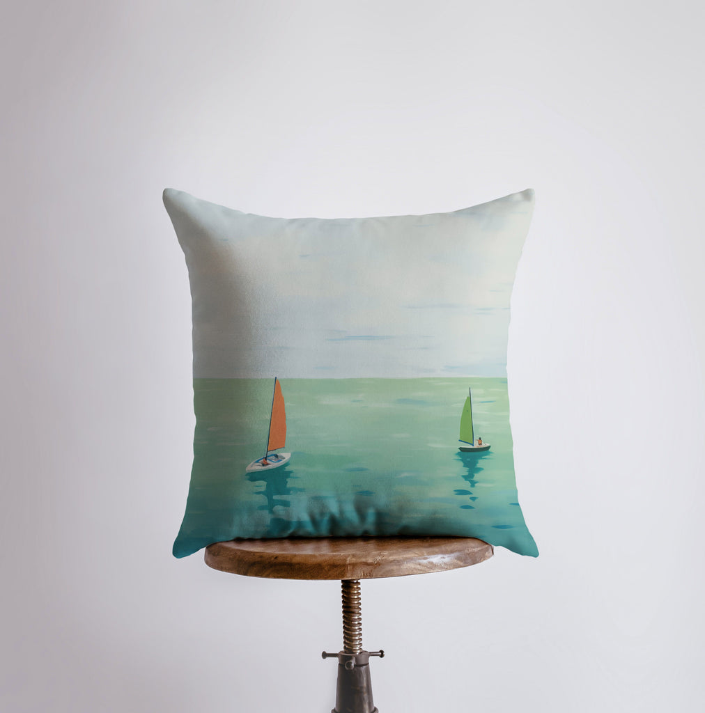 a pillow with a painting of sailboats on the water