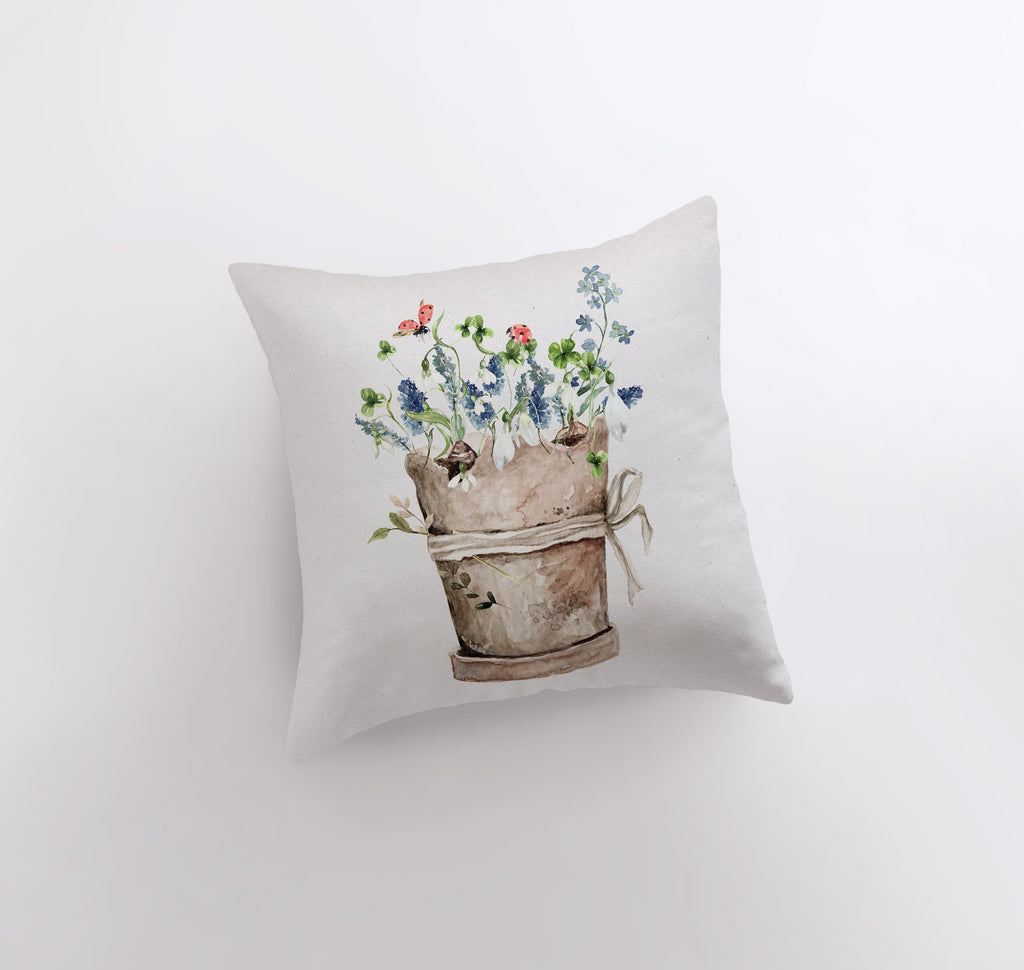 a pillow with a painting of a bucket of flowers