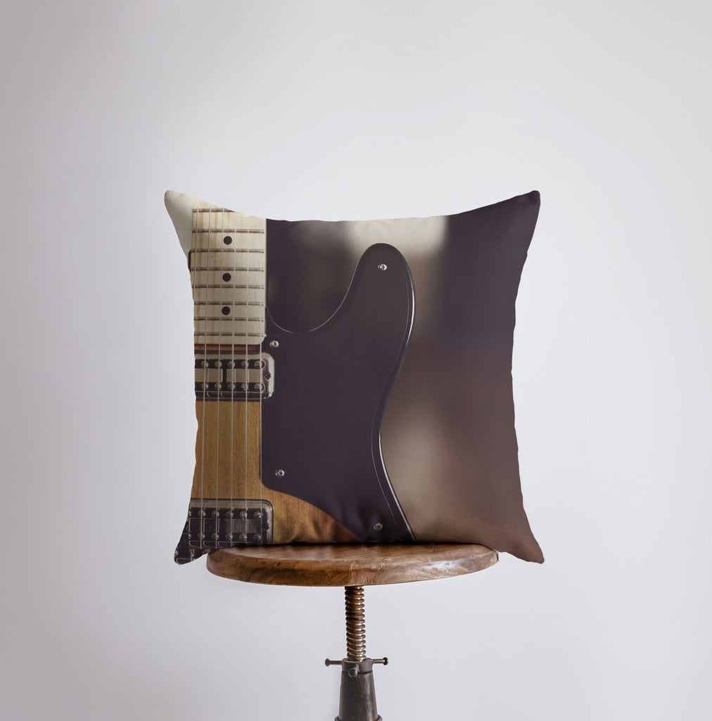 a guitar pillow sitting on top of a stool