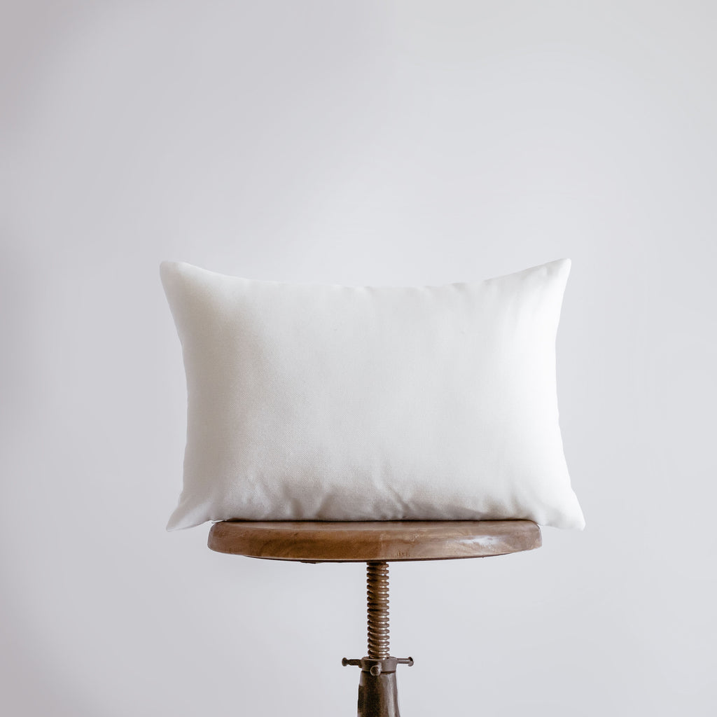 a white pillow sitting on top of a wooden table