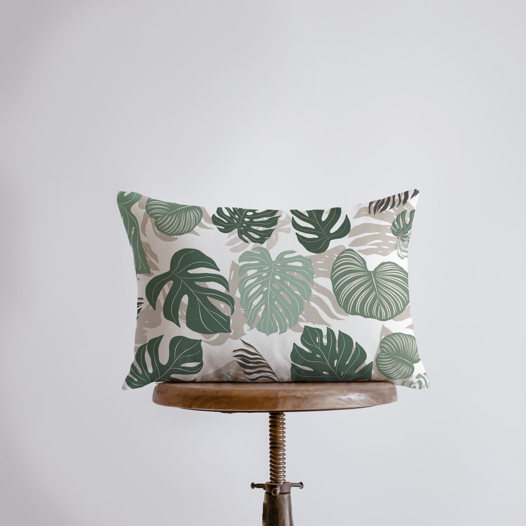 a green and white pillow sitting on top of a wooden stool