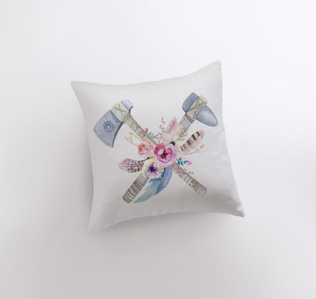 a white pillow with two axes and flowers on it