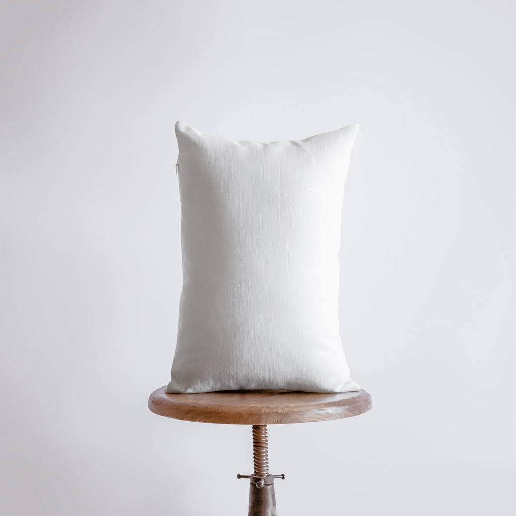 a white pillow sitting on top of a wooden chair