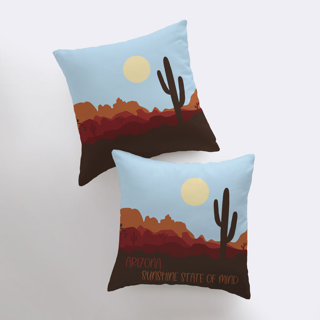 two pillows with a desert scene on them