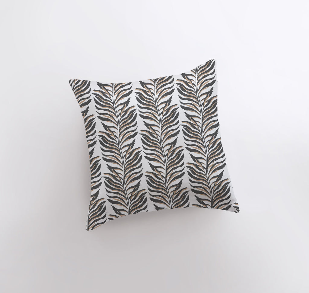 a pillow with a black and white leaf pattern on it