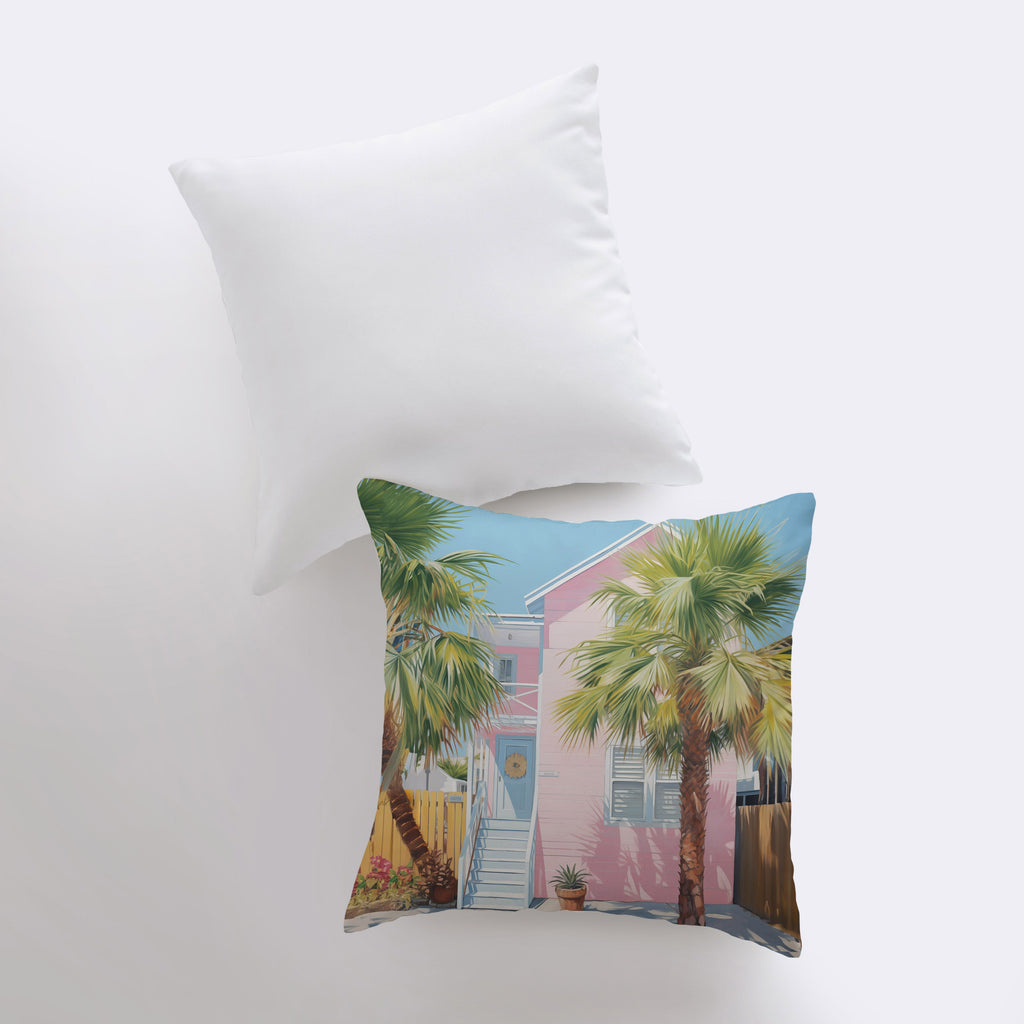 a pillow with a picture of a pink house and palm trees