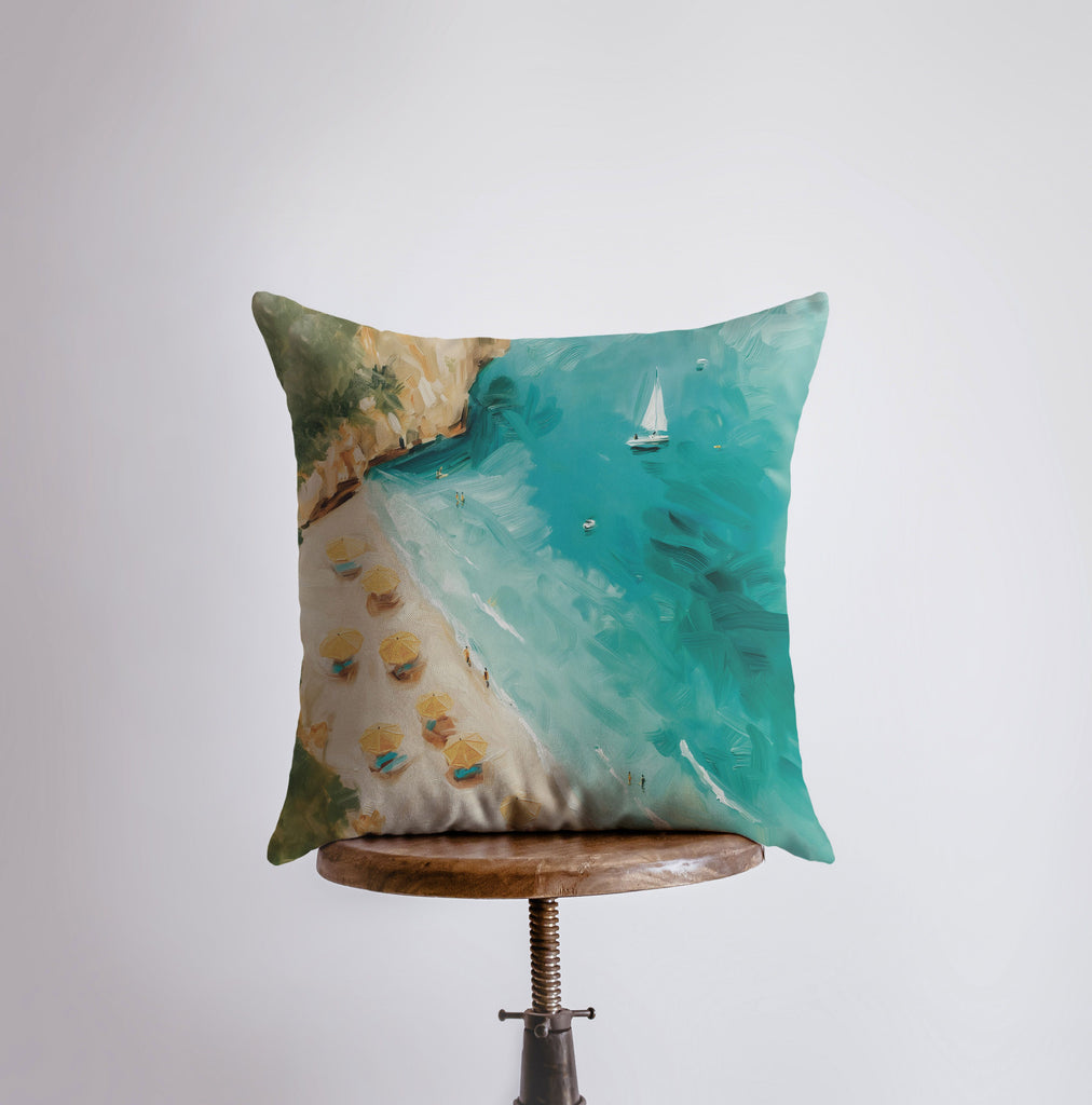 a pillow with a painting of a beach and a sailboat