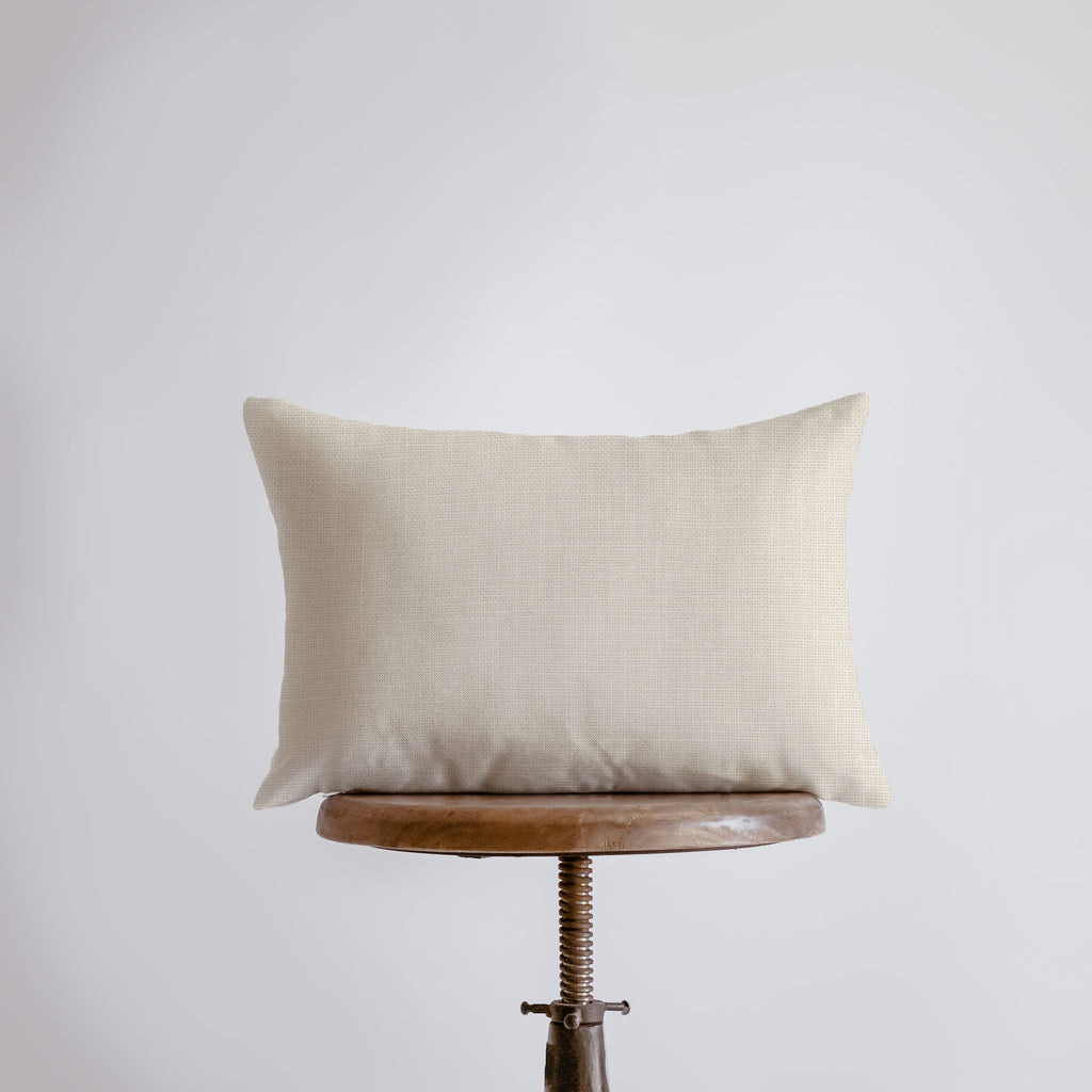 a white pillow sitting on top of a wooden table