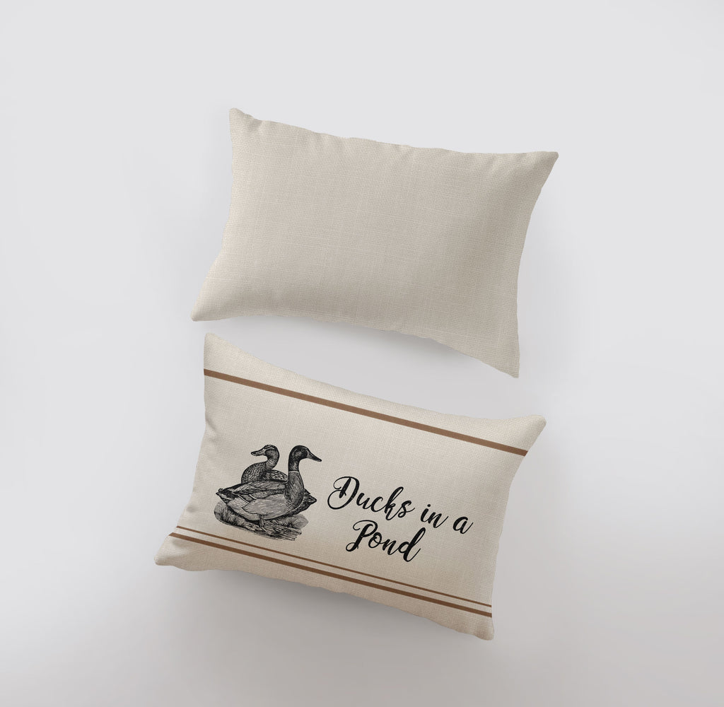 a pair of pillows with ducks in a pond on them