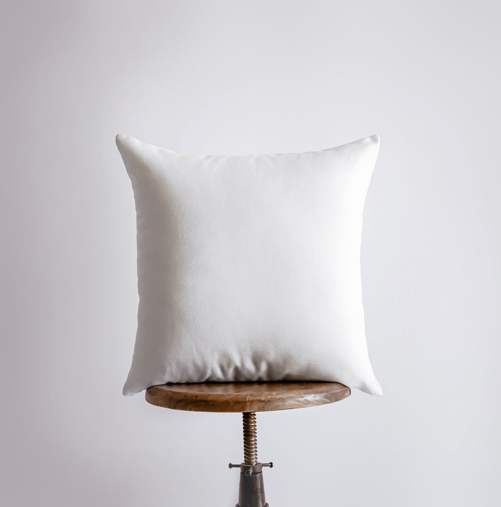 a white pillow sitting on top of a wooden table