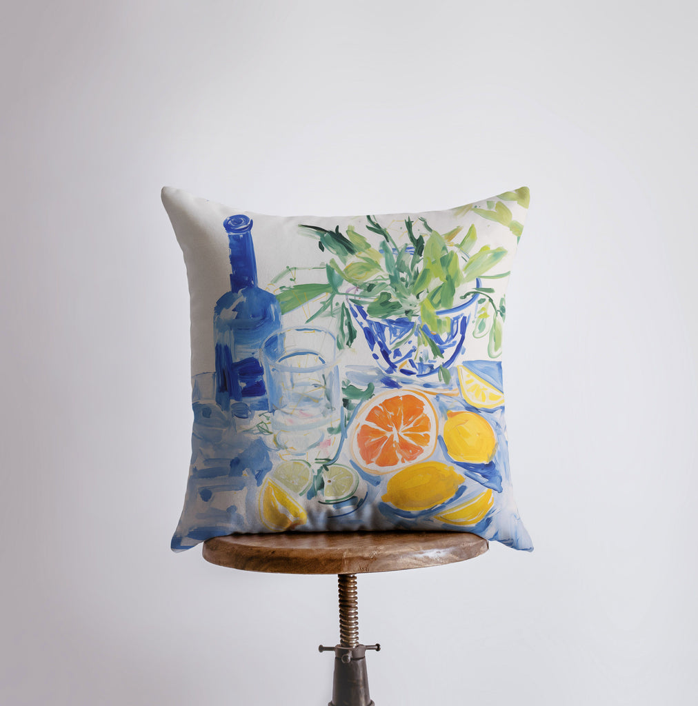 a pillow with a painting of a vase and fruit on it