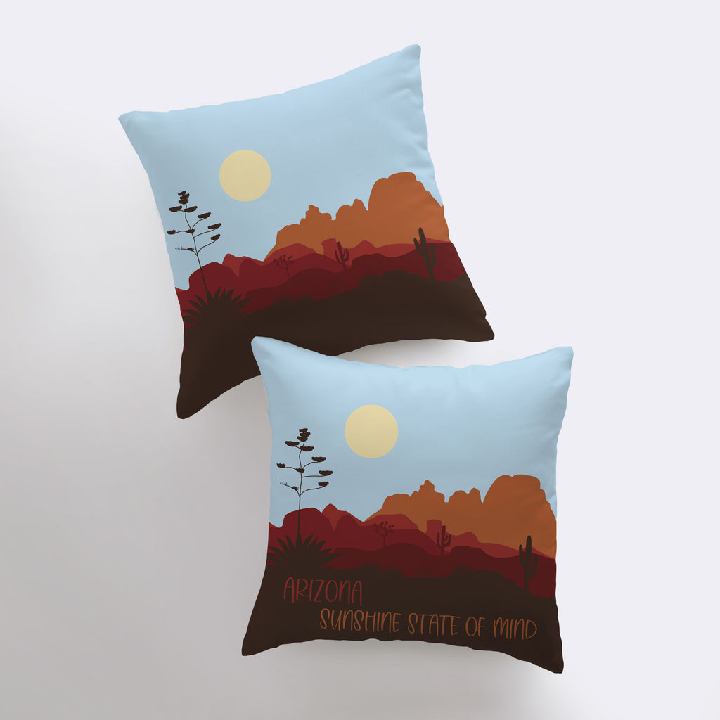 two pillows with a desert scene on them