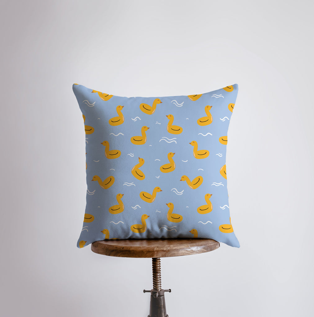 a blue pillow with yellow ducks on it