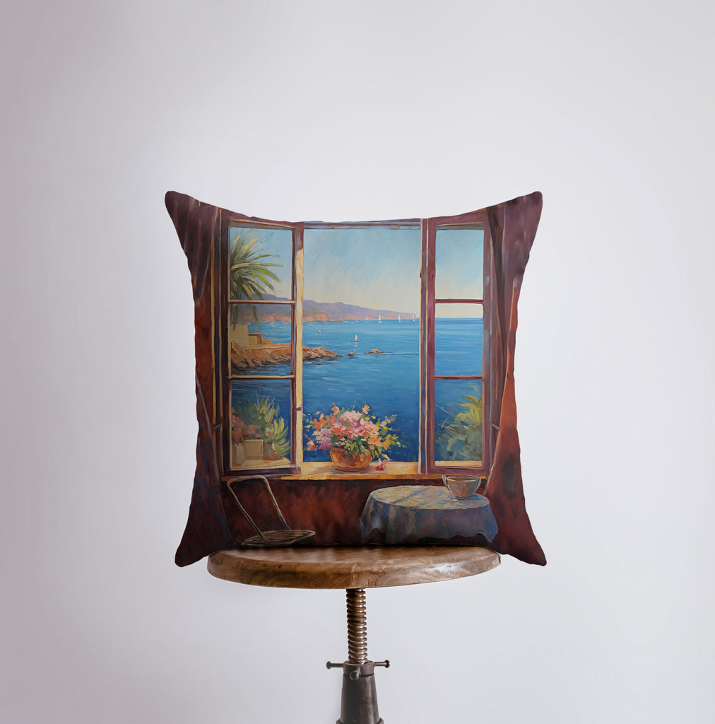 a pillow with a painting of a window overlooking a body of water