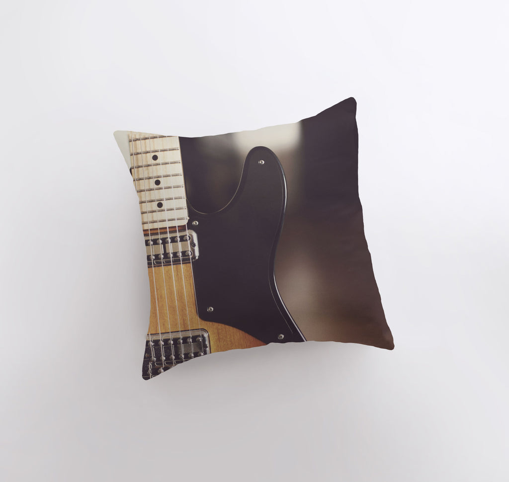 a black and brown guitar pillow on a white wall