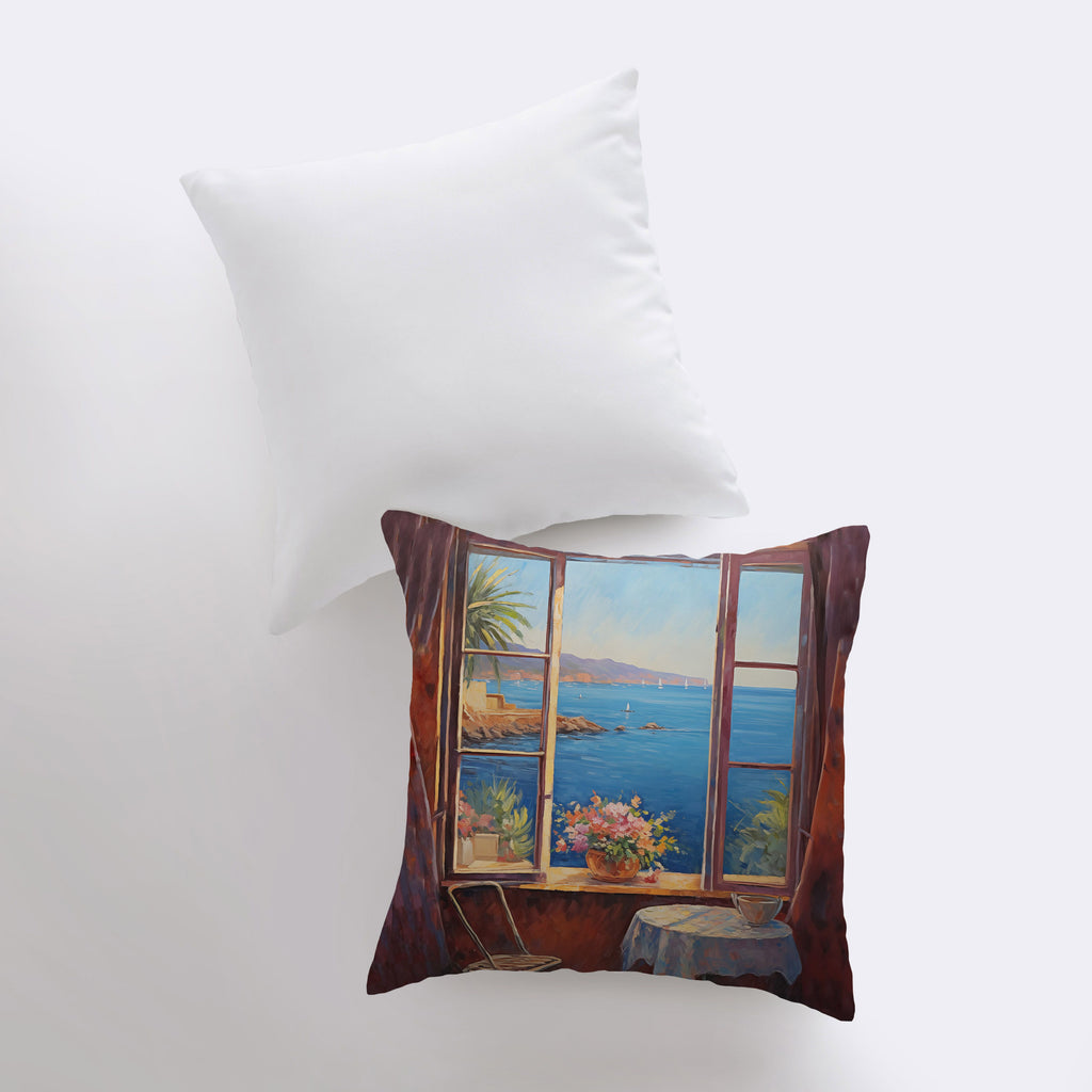 a pillow with a painting of a window overlooking a body of water