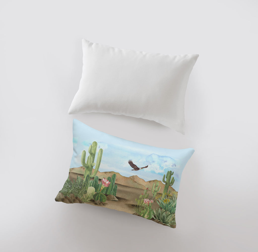 a pillow with a picture of a bird flying over a cactus