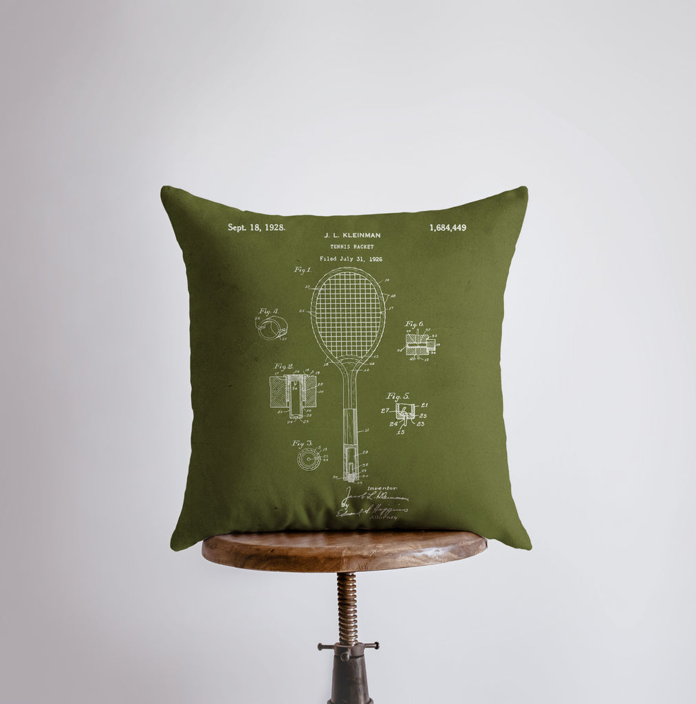 a green pillow with a tennis racket on it