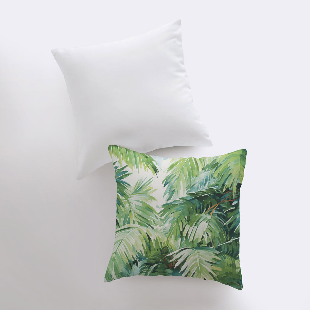 a white pillow with a green leaf print on it