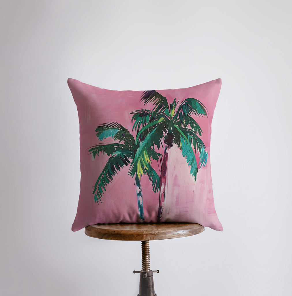 a pink pillow with a palm tree on it