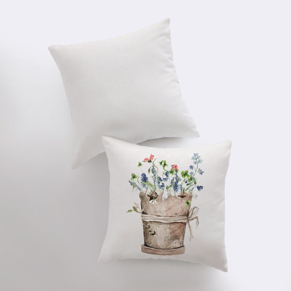 two pillows with flowers in a bucket on them